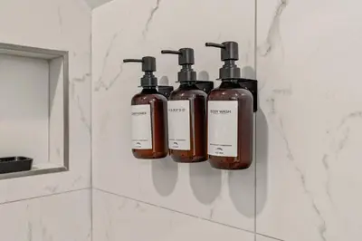 three bottles of soap on a wall in a bathroom at Townhouse SLEEP 4 Walk to Liberty Bell |Old City in Philadelphia