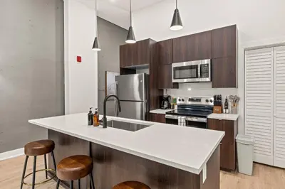 a kitchen with a white counter top and wooden cabinets at Townhouse SLEEP 4 Walk to Liberty Bell |Old City in Philadelphia