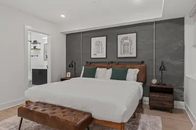 a bedroom with a large bed and a leather bench at New townhouse SLEEP 4 Best Spot-Old City Philly in Philadelphia