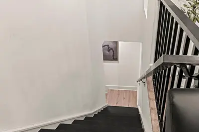 a stairway with white walls and black stairs at SLEEP 4 - Old City Philly - NEW Townhouse in Philadelphia