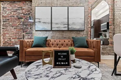 a living room with a brown couch and a table at SLEEP 4 - Old City Philly - NEW Townhouse in Philadelphia