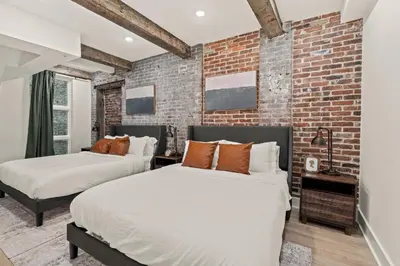 two beds in a room with a brick wall at New Townhouse Sleep 4 Old City Walk to Everything! in Philadelphia