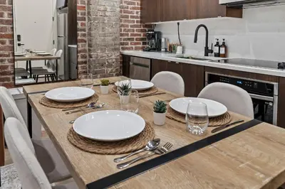 a wooden table with plates and napkins on it in a kitchen at New Townhouse Sleep 4 Old City Walk to Everything! in Philadelphia