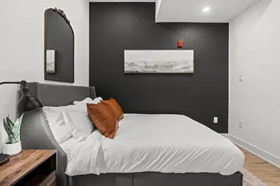 a bedroom with a bed with white sheets and orange pillows at Walk to Everything in Old City- ADA compliant unit in Philadelphia