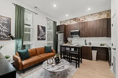 a living room with a couch and a kitchen at Walk to Everything in Old City- ADA compliant unit in Philadelphia