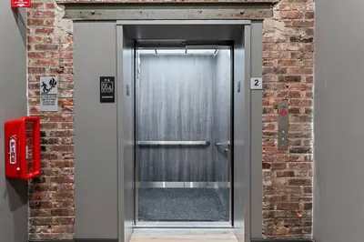 a metal elevator door in a brick wall at In The Center of Old City Philly- Walker Paradise! in Philadelphia