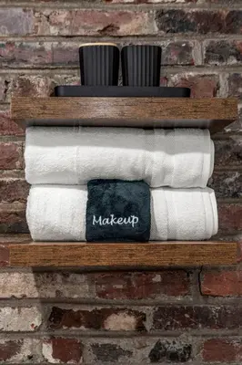 a wooden shelf with towels and toothbrushes on a brick wall at Old City-New Building Charm-Walk to Everything! in Philadelphia