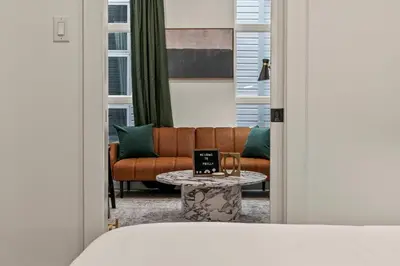 a bedroom with a couch and a table with a laptop at Old City-New Building Charm-Walk to Everything! in Philadelphia
