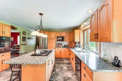 a kitchen with wooden cabinets and granite counter tops at Peaceful Countryside Retreat with Yard in Frenchtown in Frenchtown