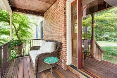 a porch with a wicker chair and a table at Peaceful Countryside Retreat with Yard in Frenchtown in Frenchtown
