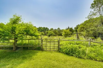 a wooden fence in a field with a tree at Peaceful Countryside Retreat with Yard in Frenchtown in Frenchtown