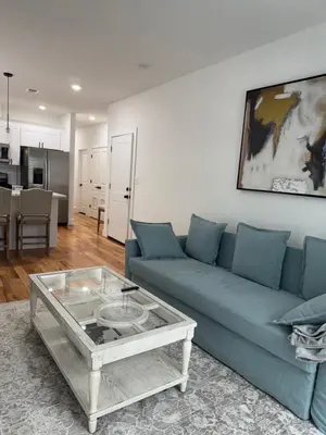 a living room with a blue couch and a coffee table at Elegant Retreat Near EWR n NYC in Newark