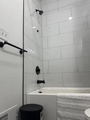 a white bathroom with a tub and a toilet at Elegant Retreat Near EWR n NYC in Newark