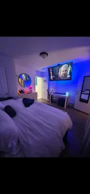 a bedroom with a white bed and a flat screen tv at The Eternal Oasis in Newark