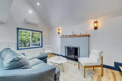 a living room with a blue couch and a fireplace at The Blakeslee Blue Escape in Blakeslee