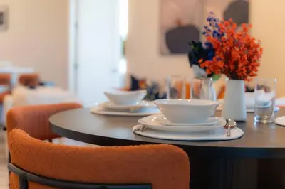 a table with plates and cups and a vase with flowers at Vibrant Visit 4BR, 4bath, Park 2cars FREE| 20% OFF in East Orange