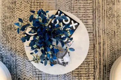 a vase with blue flowers on a plate on a table at Vibrant Visit 4BR, 4bath, Park 2cars FREE| 20% OFF in East Orange