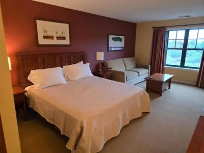 a bedroom with a bed and a couch and a chair at The Appalachian Hotel at Mountain Creek Resort - Pool, Hot Tub & Sauna in Vernon Township