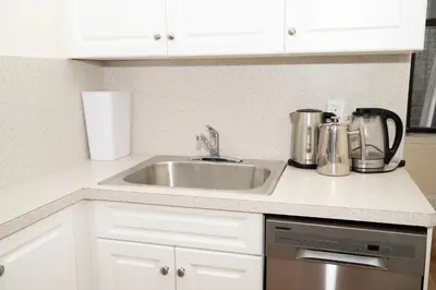 a kitchen counter with a sink and silver appliances at East Village Center Apartment7 w Full Amenities Great New York Location in New York