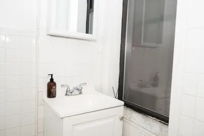 a white bathroom with a sink and a shower at East Village Center Apartment7 w Full Amenities Great New York Location in New York