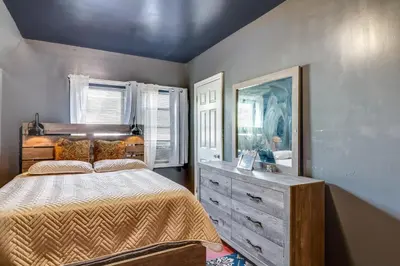 a bedroom with a bed with a dresser and a mirror at 3 Mi to Dtwn Newark Eclectic and Walkable Apt! in Newark