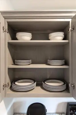 a cabinet filled with white plates and dishes at Joyful 5-Bedroom Home in Harrisburg