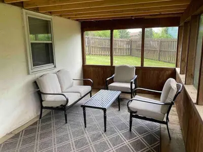 a screened porch with two chairs and a table and chairs at Joyful 5-Bedroom Home in Harrisburg