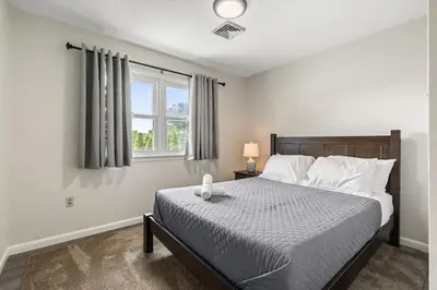 a bedroom with a large bed and a window at Joyful 5-Bedroom Home in Harrisburg