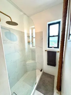 a bathroom with a shower with a glass door at Sunny Jersey City 1BR, 25 min to NYC, 15min to EWR, King Bed, Hammock & Park Views in Jersey City