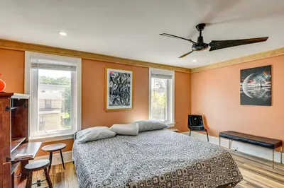 a bedroom with a bed and two windows at Walkable Location, Near PGA Champ! Updated Home