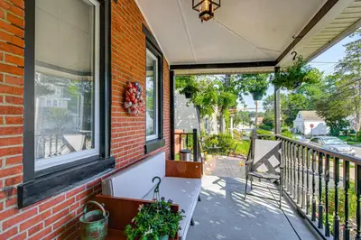 a porch with a bench on the side of a house at Walkable Location, Near PGA Champ! Updated Home