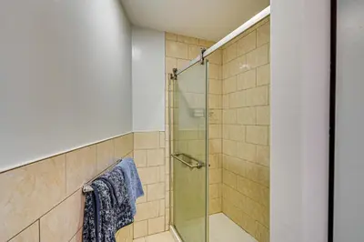 a shower with a glass door in a bathroom at Walkable Location, Near PGA Champ! Updated Home