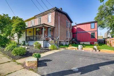 a brick house with a red garage on a street at Walkable Location, Near PGA Champ! Updated Home
