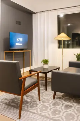 a living room with a couch and a table and a tv at Modern 2BR Cozy City Retreat Free Parking in Philadelphia