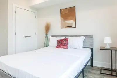 a bedroom with a white bed with a red pillow on it at 2Bed,Bath&WDWIFICentralToaster in Philadelphia
