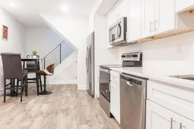 a kitchen with white cabinets and a table with chairs at 2Bed,Bath&WDWIFICentralToaster in Philadelphia