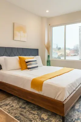 a bedroom with a large bed with orange and white pillows at Modern 2BR&2BAQueen BedWork DeskWiFiWD in Philadelphia