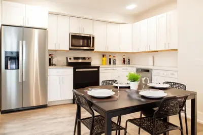 a kitchen with a table and a stainless steel refrigerator at Modern 2BR&2BAQueen BedWork DeskWiFiWD in Philadelphia