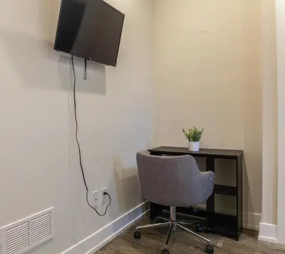 a desk with a chair and a television on a wall at 2-Bed&2-BathWDCentralKitchenWifiDesk in Philadelphia