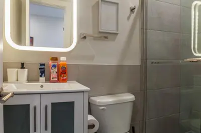 a bathroom with a toilet and a sink and a mirror at 2-Bed&2-BathWDCentralKitchenWifiDesk in Philadelphia