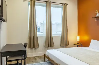 a bedroom with a bed and a desk and a window at 3BR3Bath Home with King Beds Sleeps 8 in Philadelphia