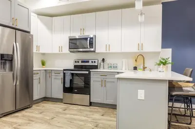 a kitchen with white cabinets and a stainless steel refrigerator at 3BR3Bath Home with King Beds Sleeps 8 in Philadelphia