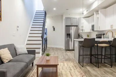 a living room with a couch and a kitchen at 3BR3Bath Home with King Beds Sleeps 8 in Philadelphia