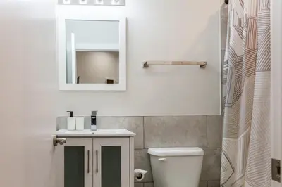 a bathroom with a sink and a mirror and a toilet at 3BR3Bath Home with King Beds Sleeps 8 in Philadelphia