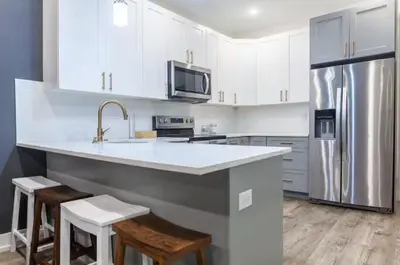 a kitchen with white cabinets and a stainless steel refrigerator at Spacious 3-Bed3BathKing BedsTVWasherDryer in Philadelphia