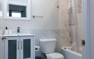 a bathroom with a toilet and a sink and a mirror at Spacious 3-Bed3BathKing BedsTVWasherDryer in Philadelphia