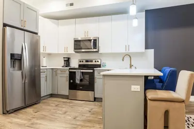 a kitchen with white cabinets and a stainless steel refrigerator at City 3Bed3BAKing Beds,Washer & Dryer,Free Parking in Philadelphia
