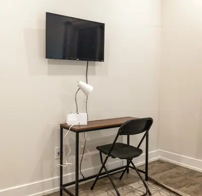 a desk with a chair and a television on a wall at City 3Bed3BAKing Beds,Washer & Dryer,Free Parking in Philadelphia