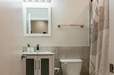 a bathroom with a sink and a mirror and a toilet at City 3Bed3BAKing Beds,Washer & Dryer,Free Parking in Philadelphia