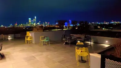 a rooftop patio with chairs and tables at night at 1bdrmapartment In The-heartofphiladelphia in Philadelphia